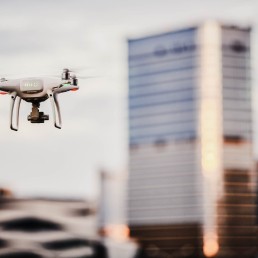 focused shot of a drone flying at city street