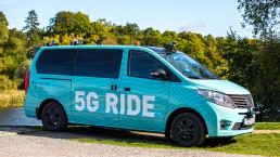 Photo from the side of the blue 5G Ride minibus with cameras on the roof