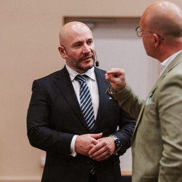 Dr Gazmend Huskaj talking to another event participant