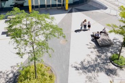 Drone photo showing five people in a city square on a sunny day